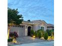 Attractive one-story home featuring manicured landscaping, a two-car garage, and elegant stone accents at 2312 Indigo Island St, Henderson, NV 89044