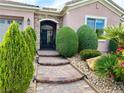 Paver walkway to arched front gate, with lush landscaping and inviting curb appeal at 2312 Indigo Island St, Henderson, NV 89044