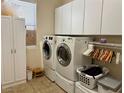 Well-organized laundry room with white cabinetry, modern washer and dryer, and ample storage space at 2312 Indigo Island St, Henderson, NV 89044