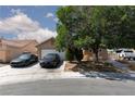 A lovely single-story home features a well-kept lawn, mature tree, and a driveway with parking at 2631 Bed Knoll Ct, North Las Vegas, NV 89031