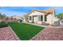 Beautiful backyard features a well-manicured lawn, desert landscaping, and an outdoor seating area at 2725 Byron Dr, Las Vegas, NV 89134
