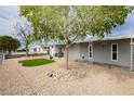 Cozy home featuring a green lawn area, mature trees, and a welcoming front porch at 419 National St, Henderson, NV 89015