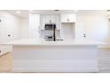 Close up of white kitchen island with sink and modern faucet, microwave and white cabinets at 508 S Jones Blvd, Las Vegas, NV 89107
