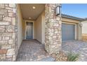 Covered front porch with stone pillars and brick pavers, leading to the home's entrance at 58 Sun Lily Ln, Henderson, NV 89011