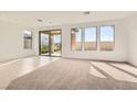 Bright living room with large windows and sliding glass door to the backyard at 58 Sun Lily Ln, Henderson, NV 89011