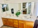Bright bathroom with dual sinks, spacious counter and a view into the bedroom at 6429 Rosemount Ave, Las Vegas, NV 89156