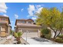 Daytime view of a two-story home featuring a two-car garage, landscaped front yard, and a welcoming facade at 9218 Grassy Weep Ct, Las Vegas, NV 89178