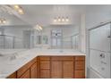 Bright bathroom featuring double sinks, ample counter space, and a glass-enclosed shower at 10410 Poplar Park Ave, Las Vegas, NV 89166