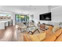Bright living room featuring wood floors, modern furniture, and sliding glass doors to the backyard at 10432 Britton Hill Ave, Las Vegas, NV 89129