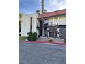 A two-story condo with a red tiled roof and stucco exterior, set amidst green landscaping at 1440 Vegas Valley Dr # 2, Las Vegas, NV 89169