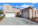 Exterior view of a stucco home with a three car garage and a well-manicured front yard at 1551 Boundary Peak Way, Las Vegas, NV 89135