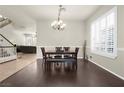 Elegant dining room with dark wood floors, wainscoting, and a modern chandelier at 1777 Antelope Valley Ave, Henderson, NV 89012