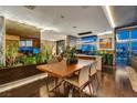 A dining room featuring hardwood floors, large windows, and a custom-built planter with integrated lighting at 353 E Bonneville Ave # 1302, Las Vegas, NV 89101