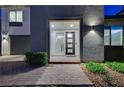 Inviting home entrance showcasing a modern glass-paneled door and stylish exterior lighting at 4177 Railhead Pass Ave, Las Vegas, NV 89141