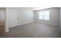 Empty living room featuring a large window for natural light and modern wood-look flooring at 5055 W Hacienda Ave # 2125, Las Vegas, NV 89118