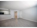 Open living room with wood-look floors, white walls, and views to other rooms at 5055 W Hacienda Ave # 2125, Las Vegas, NV 89118
