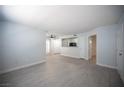 Open-concept living room featuring gray wood-look floors, view of the kitchen, and white cabinets at 5055 W Hacienda Ave # 2125, Las Vegas, NV 89118