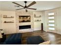 Stylish living room with a stone fireplace, floating shelves, and a ceiling fan at 600 N Carriage Hill Dr # 1082, Las Vegas, NV 89138