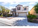 Inviting two-story house featuring a balcony, double front door, and attached two-car garage at 7098 Seabirds Pl, North Las Vegas, NV 89084