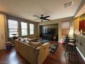 Spacious living room with hardwood floors and modern lighting flows into the open bar area at 8396 Waylon Ave, Las Vegas, NV 89178