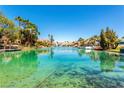 Picturesque view of the channel featuring clear, turquoise water, waterfront homes, and private docks at 8404 Shore Breeze Dr, Las Vegas, NV 89128