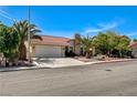 Well-maintained single-story home with a lush landscaped yard and mature trees at 8705 Orvieto Dr, Las Vegas, NV 89117