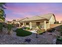 Serene backyard featuring a covered patio, lush greenery, and a rock garden for relaxation at 8797 Pinley Spring St, Las Vegas, NV 89113