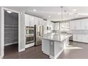 Modern kitchen features stainless steel appliances, white cabinetry, an island, and a walk-in pantry at 8797 Pinley Spring St, Las Vegas, NV 89113