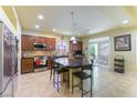 Open kitchen with dark wood cabinets, stainless steel appliances, and a granite island at 9823 Belle Marie Ct, Las Vegas, NV 89141