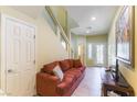Inviting living area with tile flooring, a staircase, and a comfortable sofa at 9823 Belle Marie Ct, Las Vegas, NV 89141