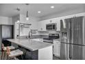 Well-lit kitchen featuring stainless steel appliances, quartz countertops, and a breakfast bar with seating at 1025 Willow Tree Dr # B, Las Vegas, NV 89128