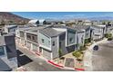 Charming townhome complex featuring modern architecture, stylish gray facades, and well-manicured landscaping, showcasing community appeal at 143 Aqua Commons Ln, Henderson, NV 89015