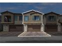 Townhome exterior showing a two-story home with a two car garage and brick paver driveway at 236 Callen Falls Ave # 1211, Henderson, NV 89011
