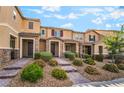 Inviting townhome showcasing lush front yard landscaping and brick walkway at 2871 Tanager Hill St, Henderson, NV 89044