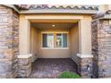 Covered front porch featuring stone pillars and a tiled floor at 2871 Tanager Hill St, Henderson, NV 89044