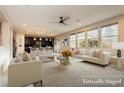 Open-concept living room with neutral decor, a ceiling fan, and an abundance of natural light at 3163 Biccari Ave, Henderson, NV 89044