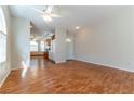 Spacious living room featuring hardwood floors, arched windows, and seamless kitchen access at 3510 Judah Way, Las Vegas, NV 89147