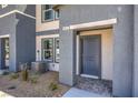 Close-up of a townhome entrance featuring a gray front door and desert landscaping at 5011 Sage Mesa Ave # Lot 143, Las Vegas, NV 89139