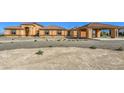 Single-story home with an attached portico, terracotta roof and desert landscaping at 5700 E Carter Ln, Pahrump, NV 89061