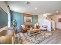 Beautifully decorated living room with modern furniture, stylish rug, and vibrant accent wall at 6104 Aster Garden St # 129, North Las Vegas, NV 89081