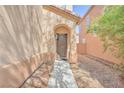 Charming home exterior featuring an arched doorway and low-maintenance landscaping at 637 Taliput Palm Pl, Henderson, NV 89011