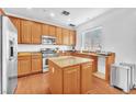 Modern kitchen features stainless appliances, wood cabinets and a center island with granite countertops at 637 Taliput Palm Pl, Henderson, NV 89011