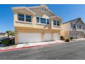 The house exterior boasts a three-car garage, lovely lawn, and a light beige facade at 6576 Buster Brown Ave # 101, Las Vegas, NV 89122