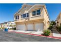 The building exterior showcases a three-car garage, neat yard, and a light beige facade at 6576 Buster Brown Ave # 101, Las Vegas, NV 89122