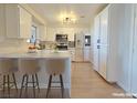 Modern kitchen boasts white cabinets, marble countertops, stainless steel appliances, and counter seating at 6853 Tamarus St # 202, Las Vegas, NV 89119