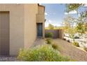 Exterior of a home showing a pathway to the front door with desert landscaping including rocks and small plants at 7777 Vino Vranec Ct, Las Vegas, NV 89113