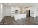 Bright modern kitchen features gray wood floors, white cabinets, stainless appliances, and a center island at 7777 Vino Vranec Ct, Las Vegas, NV 89113