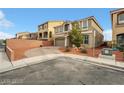 View of the home's tan exterior with desert landscaping and a brick driveway on a corner lot at 8176 Duncan Peak Ct, Las Vegas, NV 89139