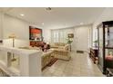 Cozy living room featuring tile flooring, a piano, neutral-toned furniture, and large windows at 8176 Duncan Peak Ct, Las Vegas, NV 89139