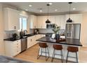 Stylish kitchen with stainless steel appliances, white cabinetry, black countertops, and a kitchen island at 933 Hunter Shores Ave, North Las Vegas, NV 89084